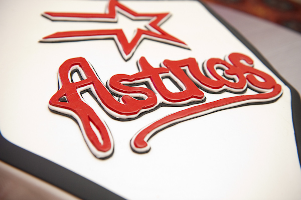 groom's cake - white cake with black border and red and black design of  the logo of the Houston Astros baseball team - photo by Houston based wedding photographer Adam Nyholt